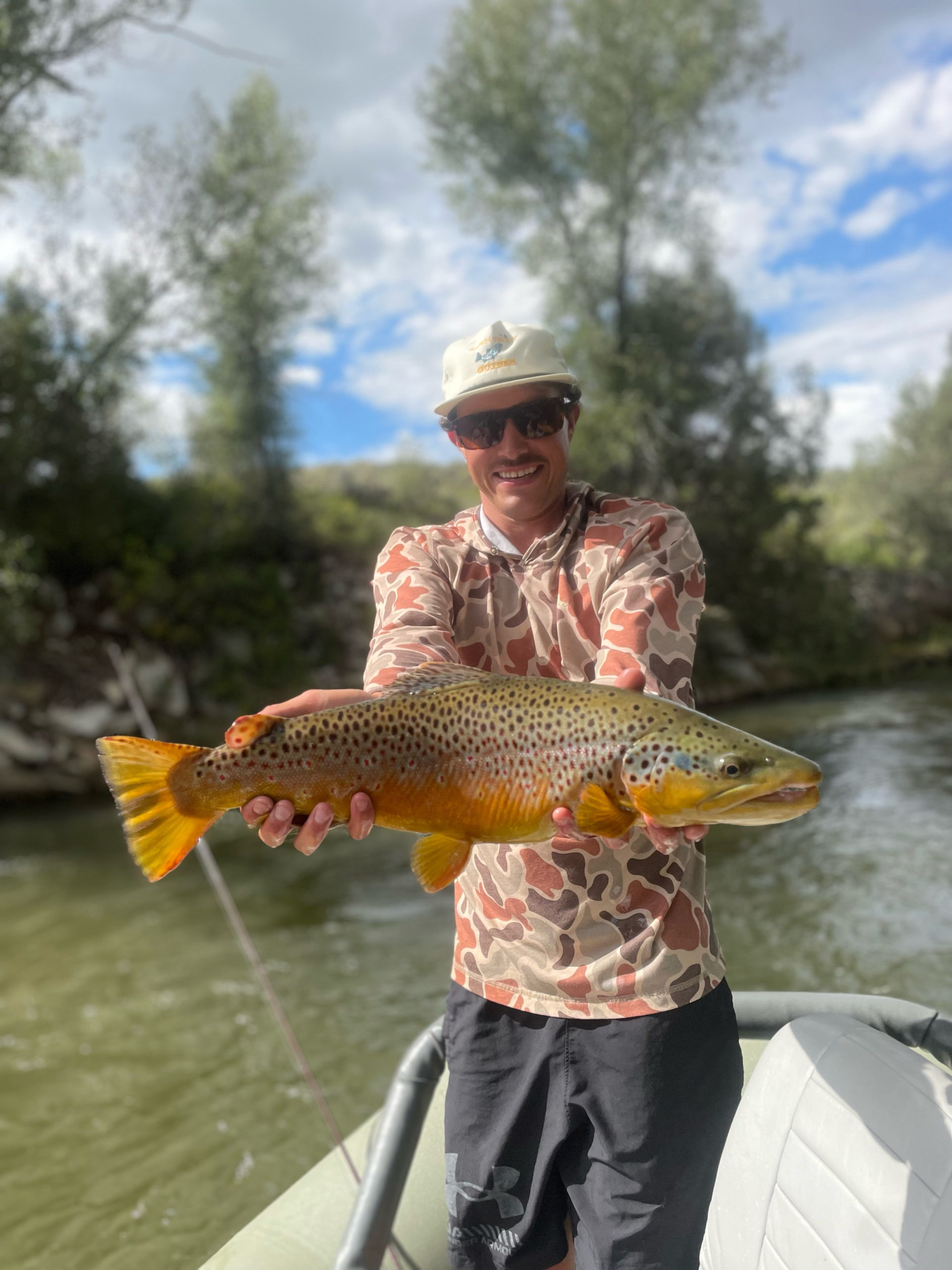 Pierce Klingbiel with large trout caught in river floating guided tour